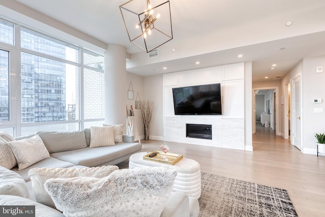 1330 Lancaster St Unit C701, Baltimore, MD 21231 - living room featuring baseboards, a chandelier, light wood-style flooring, a glass covered fireplace, and recessed lighting