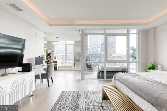 1330 Lancaster St Unit C701, Baltimore, MD 21231 - bedroom featuring wood finished floors, a desk, expansive windows, and a chandelier