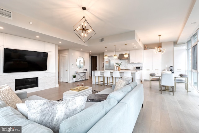 1330 Lancaster St Unit C701, Baltimore, MD 21231 - living room with a chandelier, light wood-type flooring, recessed lighting, a glass covered fireplace, and baseboards
