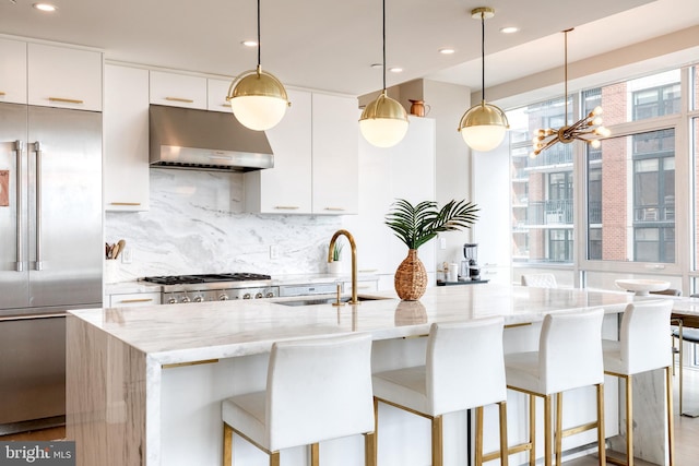 1330 Lancaster St Unit C701, Baltimore, MD 21231 - kitchen featuring under cabinet range hood, stainless steel built in fridge, decorative backsplash, a chandelier, and modern cabinets