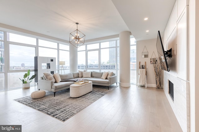 1330 Lancaster St Unit C701, Baltimore, MD 21231 - living room with a chandelier, a glass covered fireplace, light wood-style flooring, baseboards, and recessed lighting