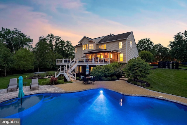 7633 Great Dover St, Gainesville, VA 20155 - back of property at dusk featuring stairway, a wooden deck, a patio area, a yard, and an outdoor pool