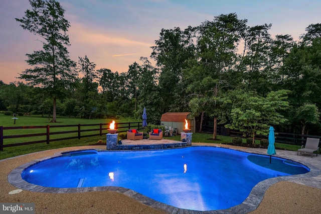 7633 Great Dover St, Gainesville, VA 20155 - pool at dusk featuring a patio, a fenced backyard, and a storage shed