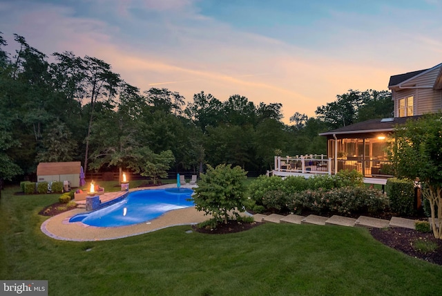 7633 Great Dover St, Gainesville, VA 20155 - pool at dusk with an outdoor pool, a lawn, a wooden deck, a storage shed, and a sunroom