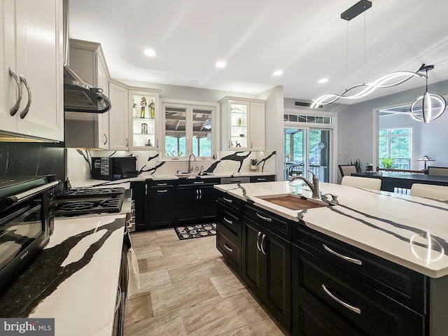 7633 Great Dover St, Gainesville, VA 20155 - kitchen featuring dark cabinetry, a sink, black microwave, pendant lighting, and recessed lighting