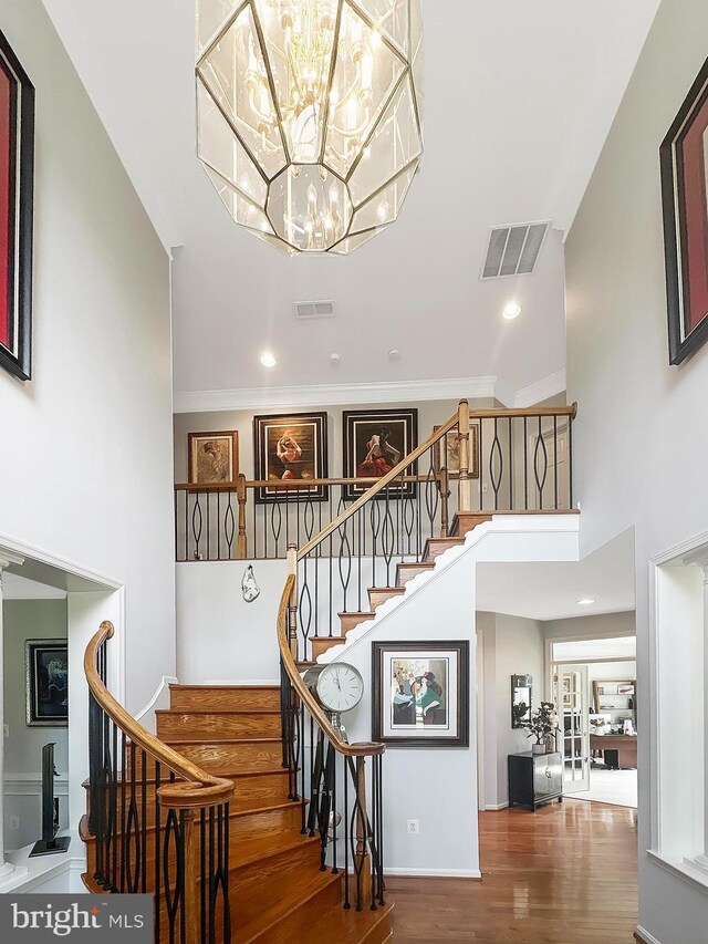 7633 Great Dover St, Gainesville, VA 20155 - stairs featuring wood finished floors, a chandelier, a high ceiling, ornamental molding, and baseboards