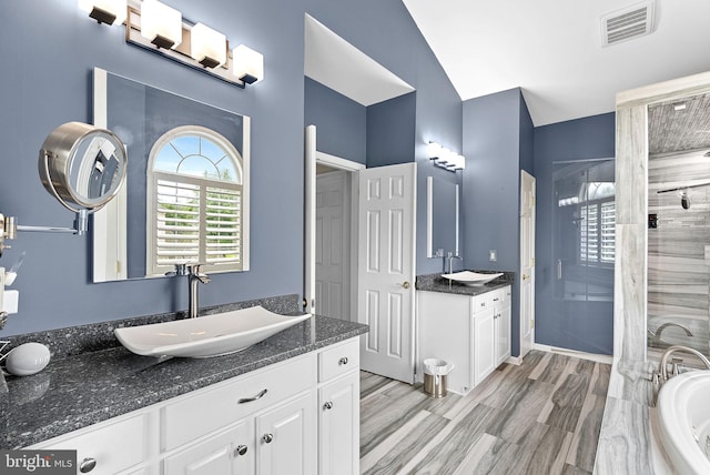 7633 Great Dover St, Gainesville, VA 20155 - bathroom featuring a shower stall, two vanities, a tub, and vaulted ceiling
