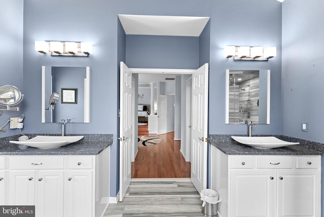 7633 Great Dover St, Gainesville, VA 20155 - bathroom with wood finished floors, a shower stall, and two vanities