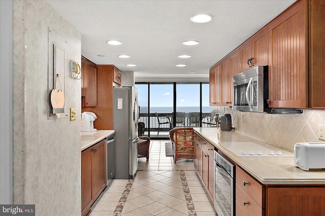 9900 Coastal Hwy Unit 401, Ocean City, MD 21842 - kitchen with appliances with stainless steel finishes, tasteful backsplash, brown cabinetry, light countertops, and recessed lighting