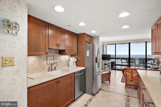 9900 Coastal Hwy Unit 401, Ocean City, MD 21842 - kitchen featuring stainless steel appliances, a sink, decorative backsplash, light countertops, and a textured ceiling