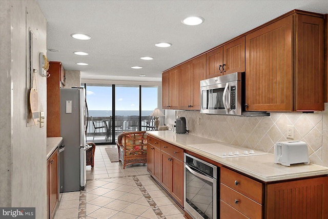 9900 Coastal Hwy Unit 401, Ocean City, MD 21842 - kitchen with stainless steel appliances, backsplash, brown cabinets, light countertops, and recessed lighting