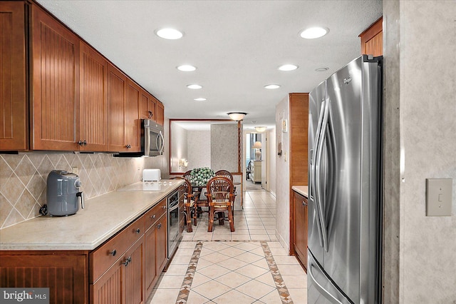 9900 Coastal Hwy Unit 401, Ocean City, MD 21842 - kitchen with stainless steel appliances, recessed lighting, decorative backsplash, light countertops, and brown cabinetry