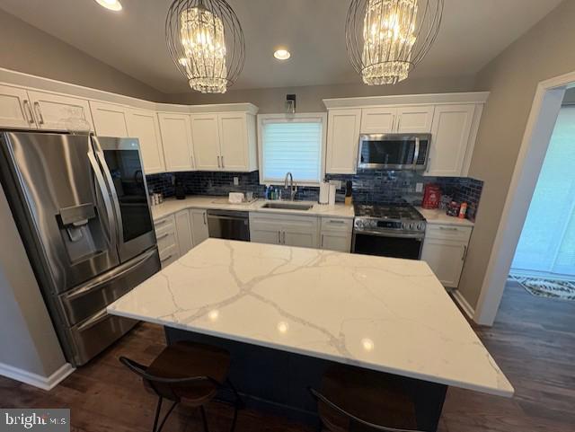 303 Ellendale Cir, Salisbury, MD 21804 - kitchen with stainless steel appliances, a chandelier, backsplash, vaulted ceiling, and recessed lighting