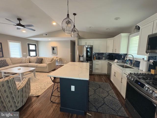 303 Ellendale Cir, Salisbury, MD 21804 - kitchen with appliances with stainless steel finishes, lofted ceiling, open floor plan, white cabinetry, and a center island