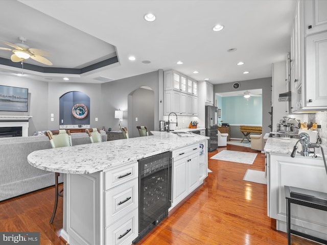 34897 Seagrass Plantation Ln, Dagsboro, DE 19939 - kitchen with a ceiling fan, open floor plan, a kitchen breakfast bar, beverage cooler, and arched walkways