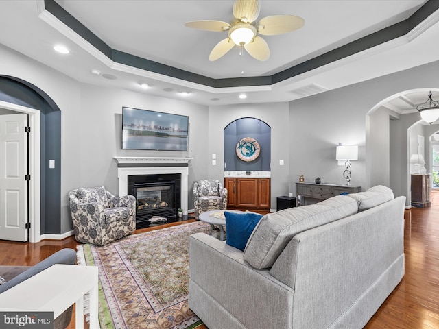 34897 Seagrass Plantation Ln, Dagsboro, DE 19939 - living room featuring arched walkways, a ceiling fan, wood finished floors, a glass covered fireplace, and recessed lighting