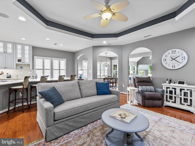 34897 Seagrass Plantation Ln, Dagsboro, DE 19939 - living area with arched walkways, recessed lighting, a tray ceiling, a ceiling fan, and wood finished floors