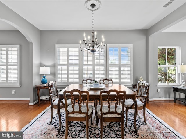 34897 Seagrass Plantation Ln, Dagsboro, DE 19939 - dining room with wood finished floors, a chandelier, arched walkways, and baseboards