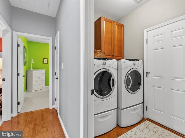 34897 Seagrass Plantation Ln, Dagsboro, DE 19939 - laundry area with cabinet space, light wood-type flooring, and washing machine and dryer