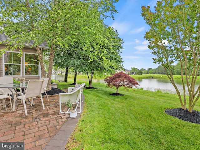 34897 Seagrass Plantation Ln, Dagsboro, DE 19939 - view of green lawn featuring a water view, a patio, and outdoor dining space