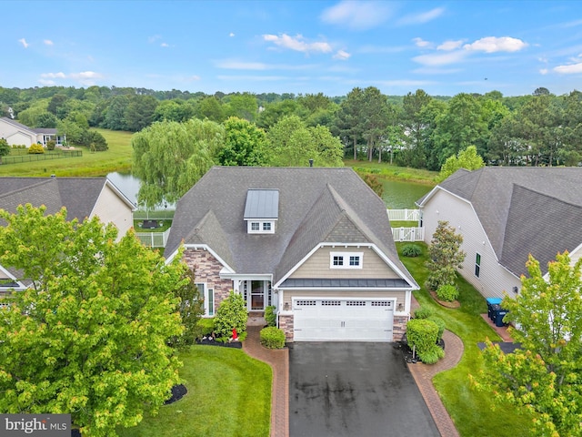 34897 Seagrass Plantation Ln, Dagsboro, DE 19939 - view of front of property featuring stone siding, a garage, asphalt driveway, a standing seam roof, and a water view