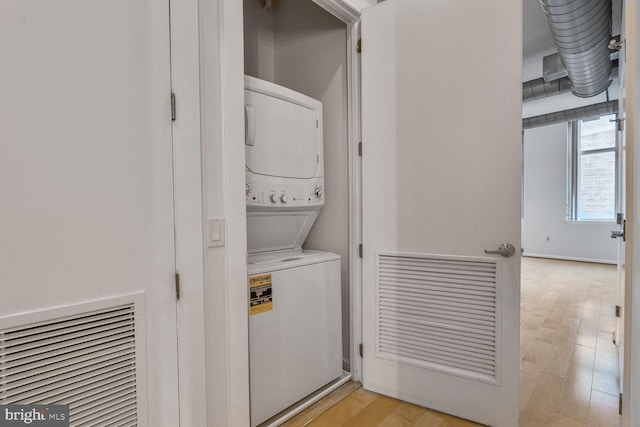 811 4th St NW Unit 320, Washington, DC 20001 - washroom featuring stacked washer and clothes dryer and light wood finished floors