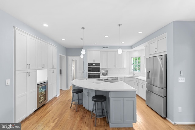 20783 Laplume Pl, Ashburn, VA 20147 - kitchen featuring stainless steel appliances, beverage cooler, a sink, white cabinets, and recessed lighting