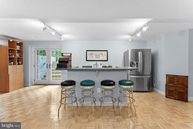 20783 Laplume Pl, Ashburn, VA 20147 - kitchen featuring stainless steel refrigerator with ice dispenser, rail lighting, baseboards, a center island, and a kitchen breakfast bar