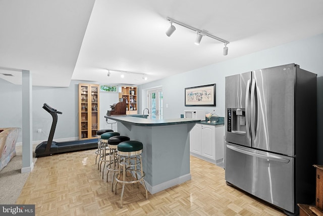 20783 Laplume Pl, Ashburn, VA 20147 - kitchen featuring stainless steel fridge, rail lighting, dark countertops, and a breakfast bar area