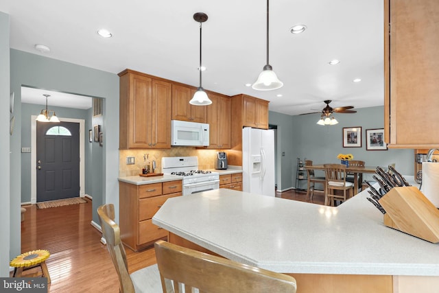 14428 William Carr Ln, Centreville, VA 20120 - kitchen with white appliances, a peninsula, light wood-type flooring, ceiling fan, and backsplash