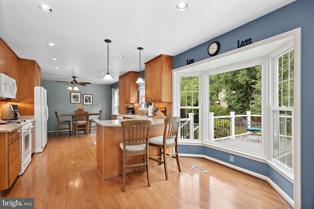 14428 William Carr Ln, Centreville, VA 20120 - kitchen featuring white appliances, light countertops, recessed lighting, a peninsula, and light wood-style flooring