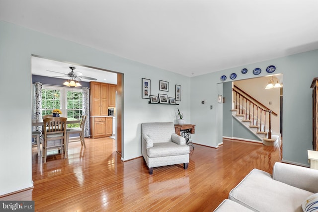 14428 William Carr Ln, Centreville, VA 20120 - living room with light wood finished floors, stairway, ceiling fan, and baseboards
