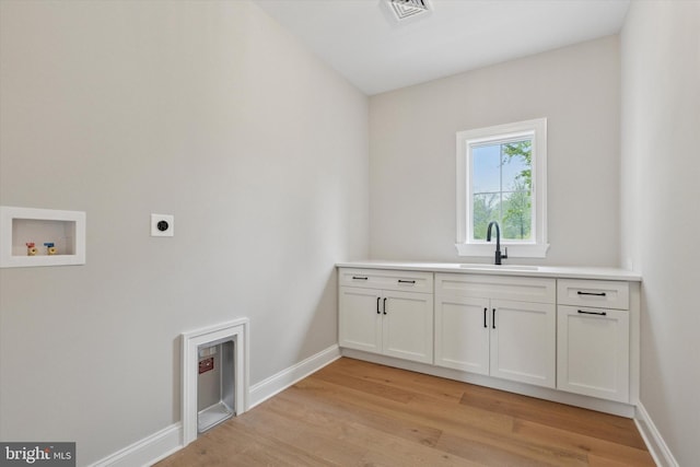 215 S Spring Mill Rd, Villanova, PA 19085 - washroom with hookup for an electric dryer, hookup for a washing machine, light wood-style floors, baseboards, and cabinet space