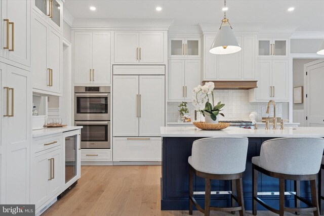 215 S Spring Mill Rd, Villanova, PA 19085 - kitchen with double oven, built in fridge, light countertops, a breakfast bar, and white cabinets