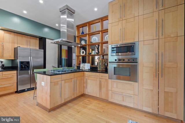 135 13th St NE, Washington, DC 20002 - kitchen with stainless steel appliances, light brown cabinetry, island range hood, a peninsula, and light wood-type flooring