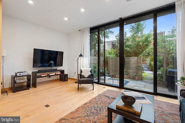 135 13th St NE, Washington, DC 20002 - living room featuring a wall of windows, recessed lighting, wood finished floors, and baseboards