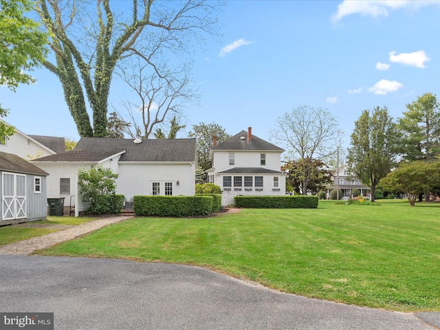 417 S Main St, Berlin, MD 21811 - view of front of house featuring a front lawn, a chimney, a shingled roof, and board and batten siding