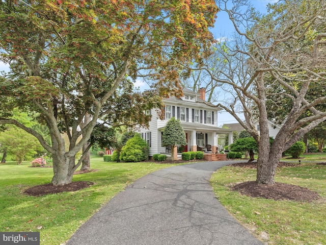 417 S Main St, Berlin, MD 21811 - traditional style home featuring covered porch, a chimney, a front lawn, and asphalt driveway
