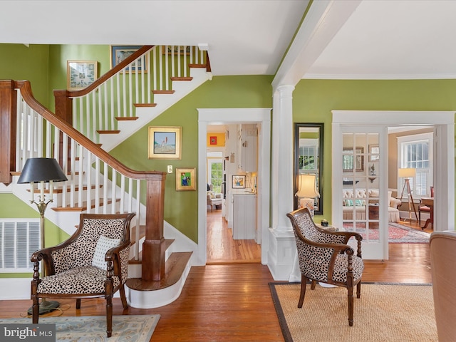 417 S Main St, Berlin, MD 21811 - staircase featuring wood finished floors, ornate columns, and ornamental molding