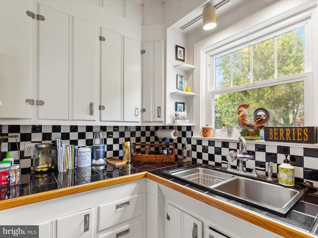 417 S Main St, Berlin, MD 21811 - kitchen with white cabinetry, a sink, and decorative backsplash