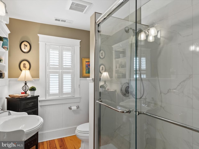417 S Main St, Berlin, MD 21811 - bathroom featuring a marble finish shower, wood finished floors, toilet, wainscoting, and vanity