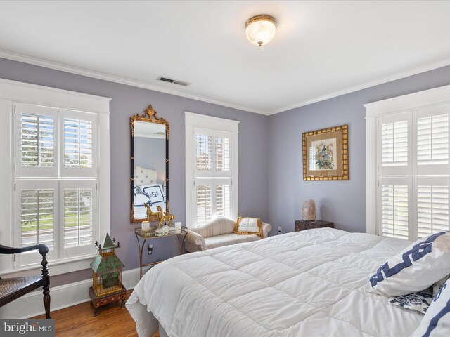 417 S Main St, Berlin, MD 21811 - bedroom with multiple windows, crown molding, wood finished floors, and baseboards