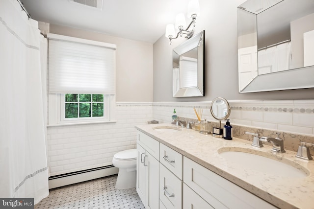 276 Cherry Ln, Doylestown, PA 18901 - bathroom featuring a baseboard radiator, double vanity, tile walls, toilet, and wainscoting