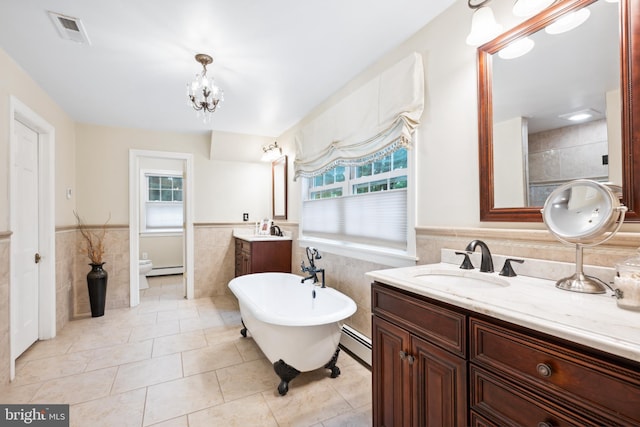 276 Cherry Ln, Doylestown, PA 18901 - full bath with tile walls, plenty of natural light, baseboard heating, a wainscoted wall, and two vanities