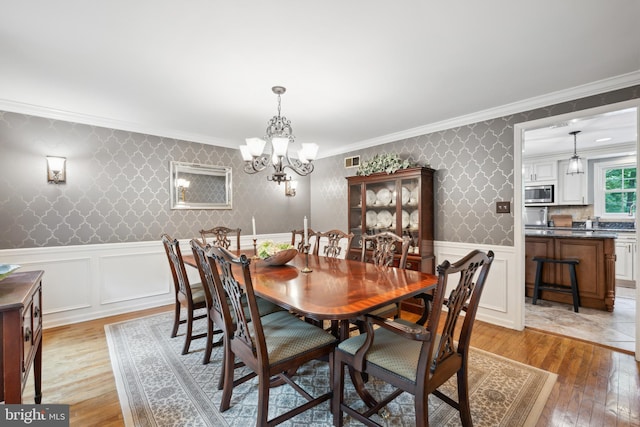 276 Cherry Ln, Doylestown, PA 18901 - dining space with light wood-style flooring, ornamental molding, wallpapered walls, a chandelier, and a wainscoted wall