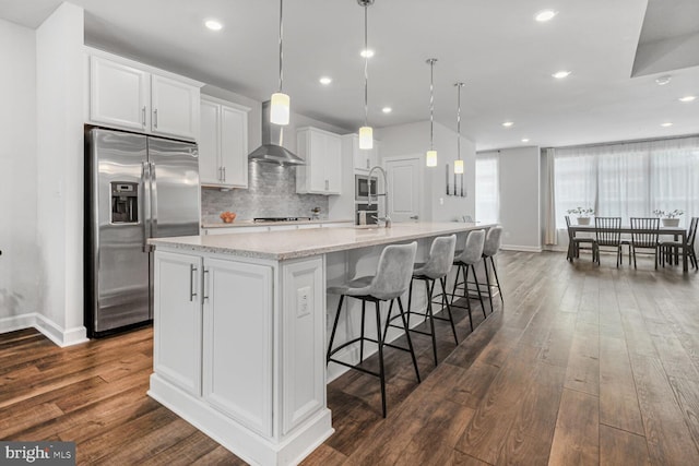 22287 Cornerstone Crossing Ter, Ashburn, VA 20148 - kitchen with stainless steel appliances, wall chimney range hood, dark wood-style floors, a spacious island, and recessed lighting