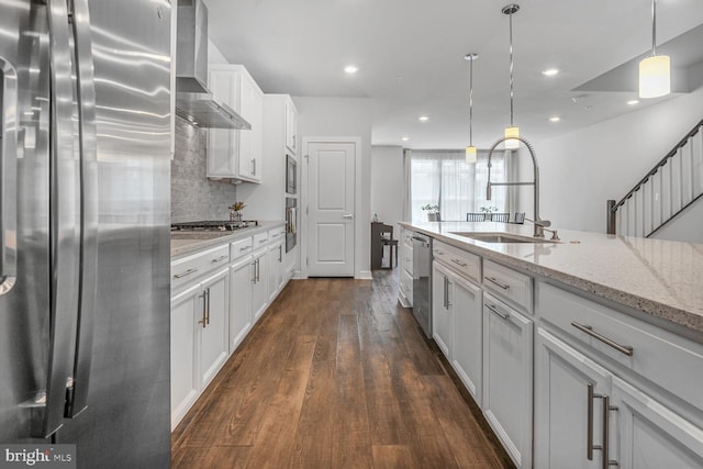 22287 Cornerstone Crossing Ter, Ashburn, VA 20148 - kitchen featuring stainless steel appliances, wall chimney range hood, white cabinetry, light stone countertops, and dark wood finished floors