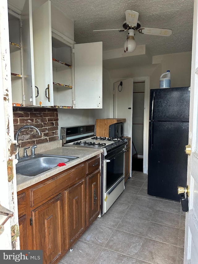 1902 T St SE, Washington, DC 20020 - kitchen featuring range with gas cooktop, freestanding refrigerator, open shelves, a sink, and light tile patterned flooring