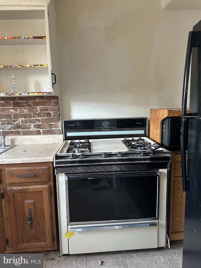 1902 T St SE, Washington, DC 20020 - kitchen with white gas range oven, freestanding refrigerator, and light countertops
