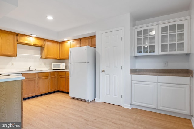 21055 Cornerpost Sq, Ashburn, VA 20147 - kitchen with white appliances, light wood-style floors, glass insert cabinets, and recessed lighting